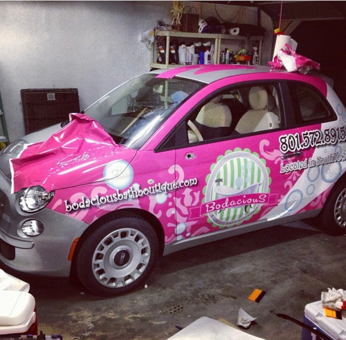 Dan Workman's first vehicle wrap — a pink Bodacious Bath Boutique Fiat 500 being installed in his parents' garage, 2013